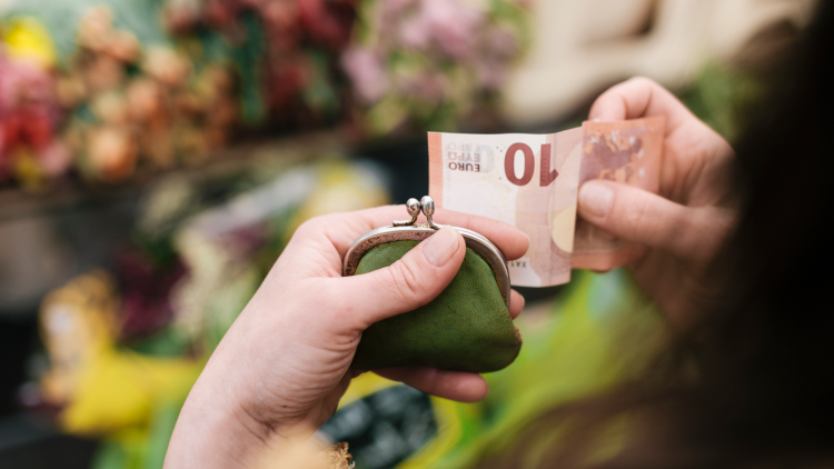 A person handles a ten euro banknote