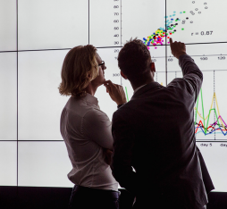 Des chercheurs analysent des données sur un tableau numérique.