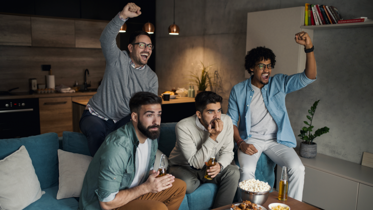 A group of friends watching a match on TV