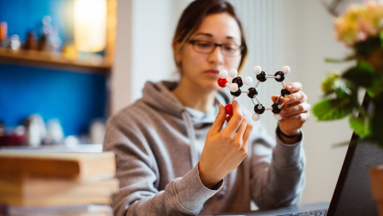 A woman holds a molecular model