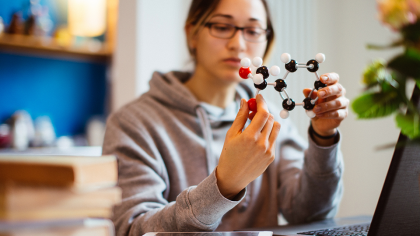 A woman holds a molecular model