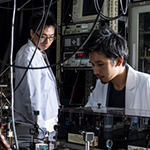 Two researchers working on a quantum simulator
