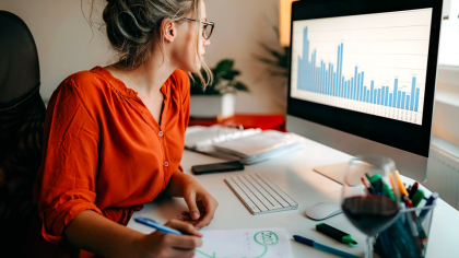 A woman in front of a computer analyzing electricity consumption data