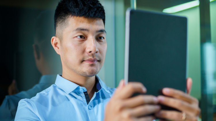 Un homme se faisant scanner le visage par une tablette pour une meilleure reconnaissance audiovisuelle