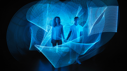 Deux personnes se tiennent la main entourées de lumières bleues