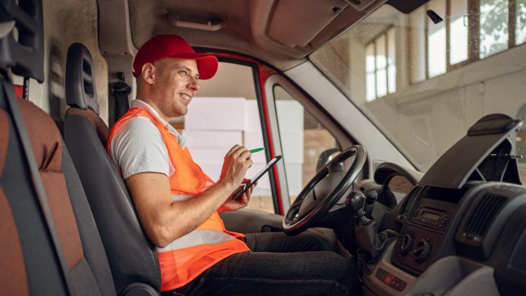 Un livreur avec une tablette dans son camion
