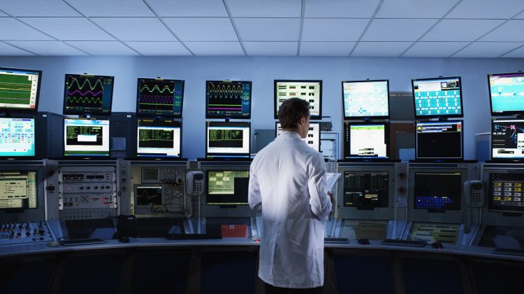 Scientist monitoring computers in control room
