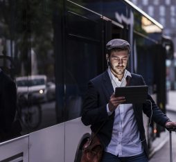 Un homme avec une tablette à côté d'un bus
