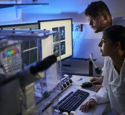Deux scientifiques examinent des données sur un écran dans un laboratoire