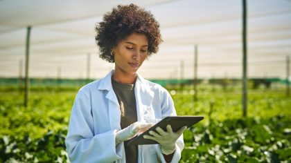 Getty Images - young scientist using a digital tablet while working with crops on a farm