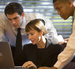 Getty Images - A photo of three businesspeople working together in front of a laptop computer.