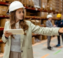 Getty Images - With a tablet in hand, a female warehouse owner walks through her busy warehouse. Dressed in smart business attire, reviewing logistics or inventory data. The spacious warehouse with neatly stocked shelves provides a clear view of the scale of the operation, emphasizing the owners hands-on approach to managing her business.