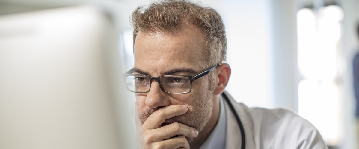 Getty Images - Cape Town, South Africa, Doctor sitting at desk working on computer