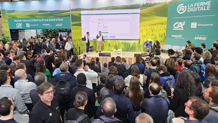 Une foule attentive assiste à une présentation sur scène lors d'un événement