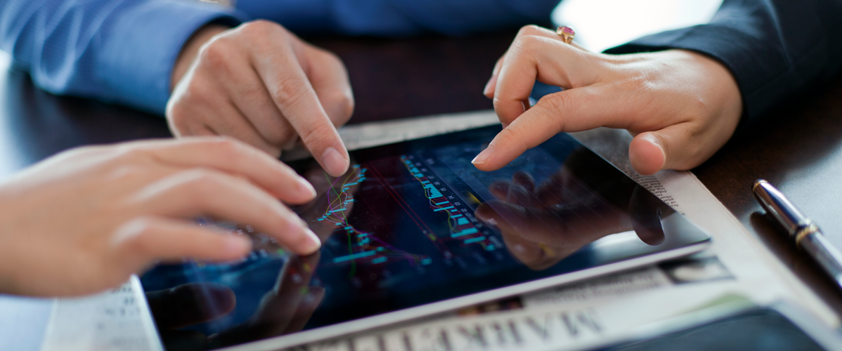 Trois personnes comparent des données sur une tablette.