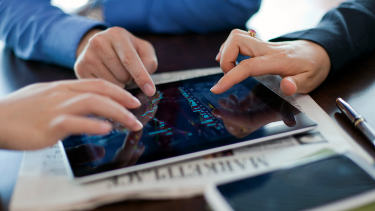 Trois personnes comparent des données sur une tablette.