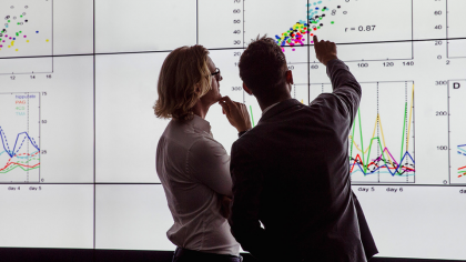 Des chercheurs analysent des données sur un tableau numérique.