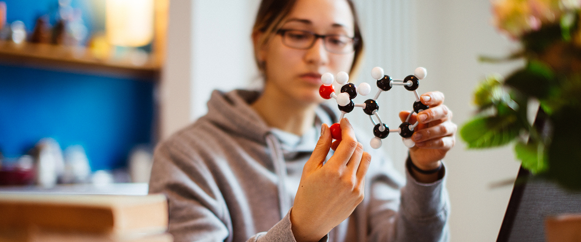 A woman holds a molecular model