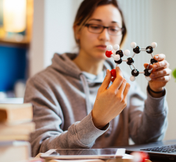 A woman holds a molecular model