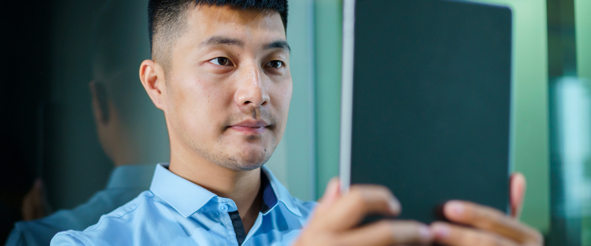 A man having his face scanned by a tablet for better audiovisual recognition