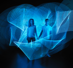 Deux personnes se tiennent la main entourées de lumières bleues