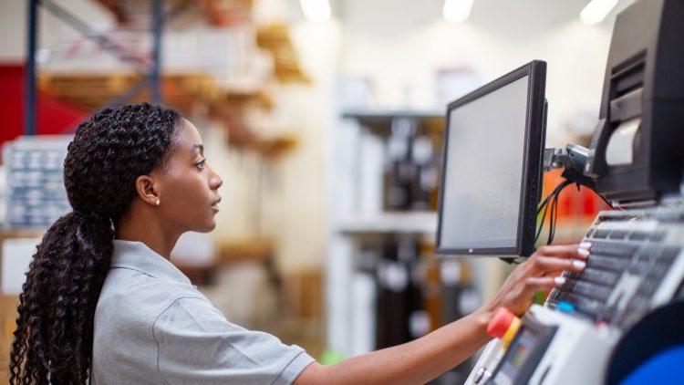 Une femme observe des données sur un écran dans une usine