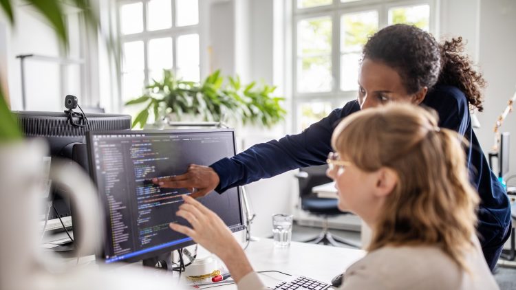 Deux femmes commentent du code à l'écran