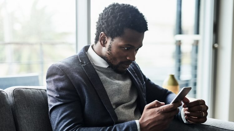 Un homme regarde avec surprise son smartphone