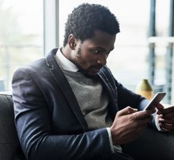 Un homme regarde avec surprise son smartphone