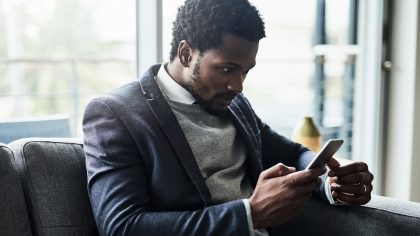 Un homme regarde avec surprise son smartphone