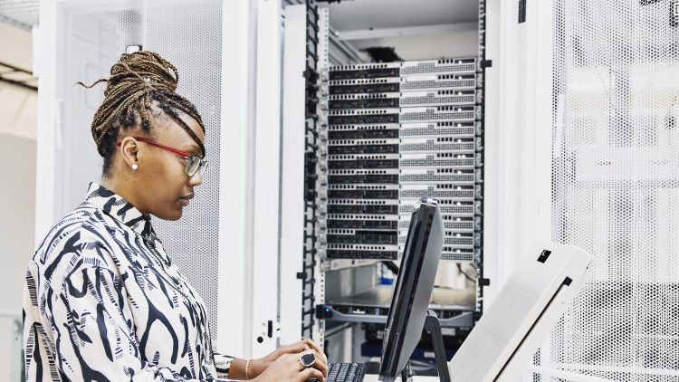 Une informaticienne configure un serveur dans un datacenter