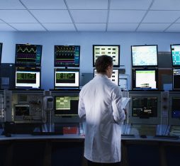 Scientist monitoring computers in control room