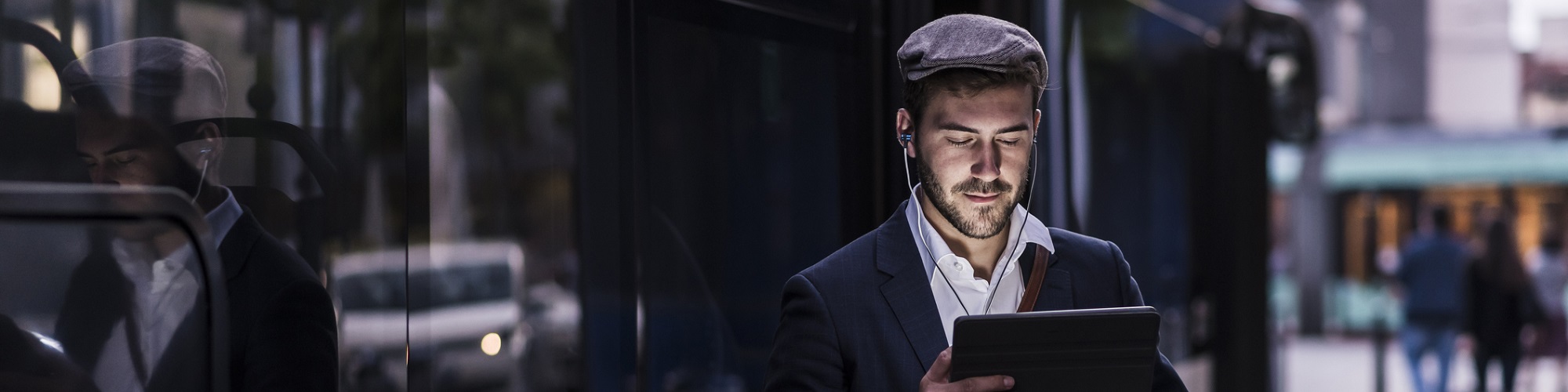 Un homme avec une tablette à côté d'un bus