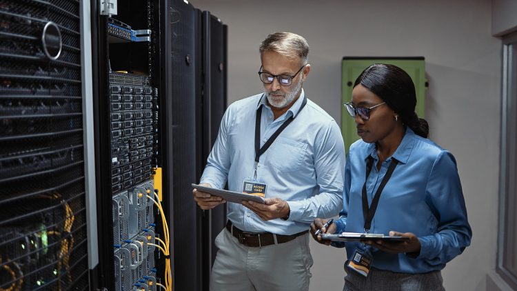 Un homme et une femme à côté d'une armoire informatique