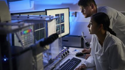 Deux scientifiques examinent des données sur un écran dans un laboratoire