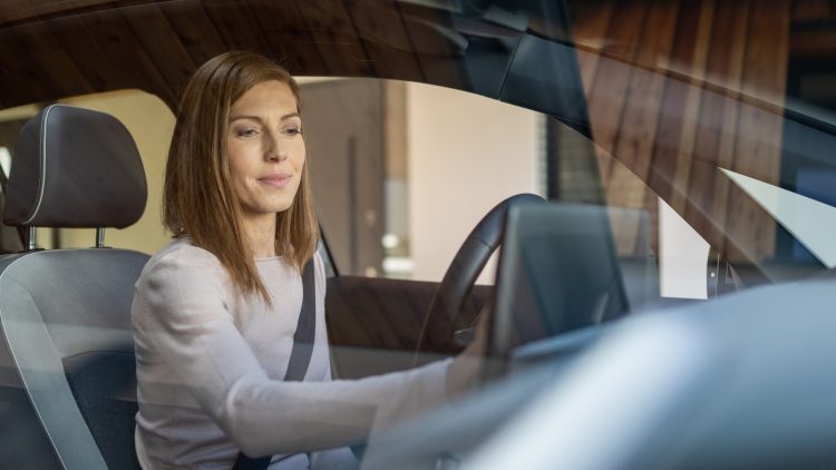 A driver uses global positioning system in her car / Une conductrice utilise un système GPS dans sa voiture