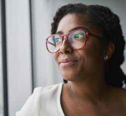 Getty Images - Portrait of cheerful businesswoman looking out window in conference room