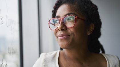 Getty Images - Portrait of cheerful businesswoman looking out window in conference room