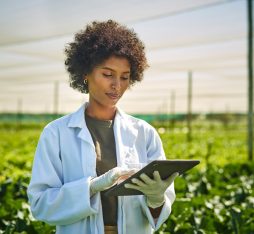Getty Images - young scientist using a digital tablet while working with crops on a farm