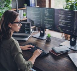 GettyImages - Photo of smart concentrated lady web designer write key words download media database upgrade modern device indoor room workstation.