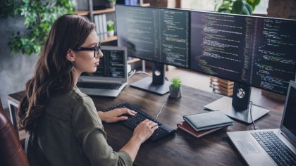 GettyImages - Photo of smart concentrated lady web designer write key words download media database upgrade modern device indoor room workstation.