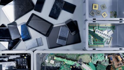 Various electronic devices, such as phones and tablets, along with internal components, are arranged in bins.