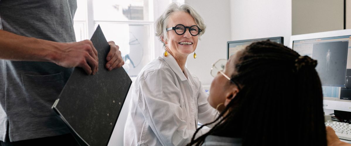 Équipe de recherche travaillant ensemble dans un laboratoire, échangeant autour de données sur écran.