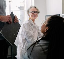 Équipe de recherche travaillant ensemble dans un laboratoire, échangeant autour de données sur écran.