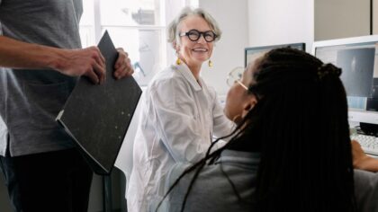 Research team working together in a laboratory, discussing data displayed on screens.