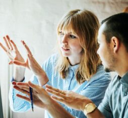 Two professionals reviewing a screen together in a bright office, illustrating human oversight and coordination in a technology project.